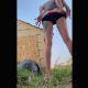 A girl takes a long, massive shit in her own backyard. Action is recorded a bit off-center. Vertical format video. About half a minute.